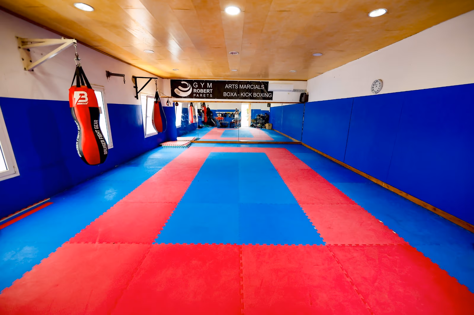 Sala d'arts marcials amb tatami i sacs de boxa i kick boxing